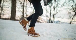 Femme dans la neige avec bottes fourrées marron
