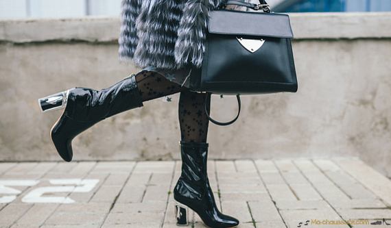 Bottes de luxe portées par une femme marchant dans la rue