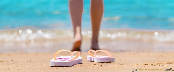 Femme avec des sandales transparentes à la plage