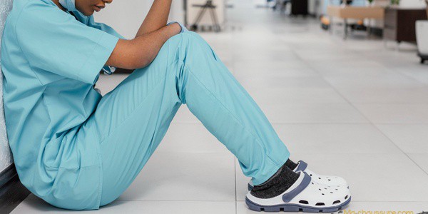Femme qui porte des chaussures de sécurité hôpital assise dans un couloir